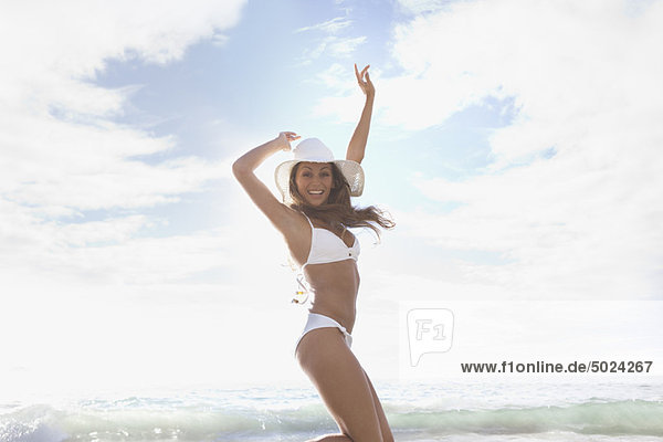 Woman wearing sunhat and bikini on beach