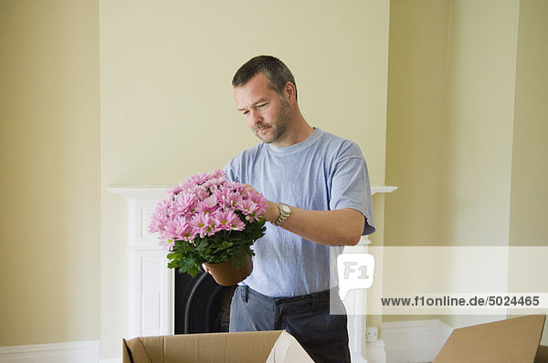 Mann Blume verpacken Eigentumswohnung neues Zuhause