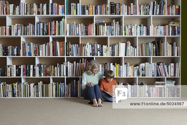 Bücherregal  Frau  Enkelsohn  vorlesen