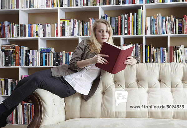Girl reading on couch in library