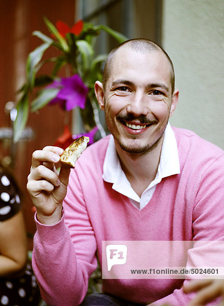 Portrait of man eating toast