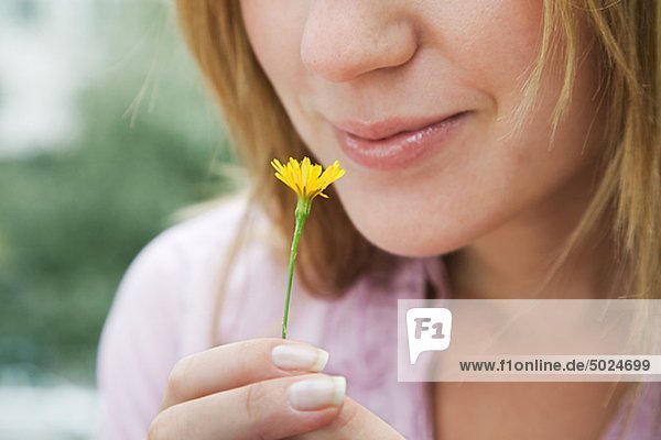 Close up of Woman smelling gelbe Blume
