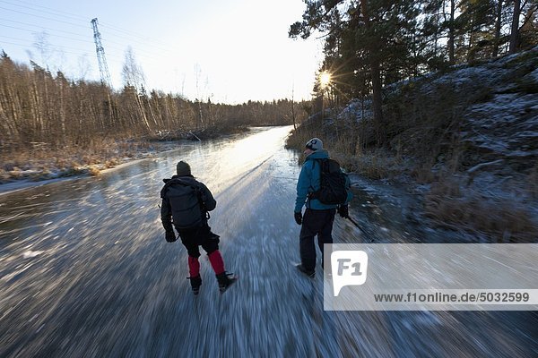 Zwei Personen Eislaufen am gefrorenen creek