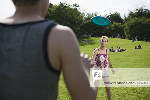 Teenager Mädchen und Junge spielen Frisbee im Park