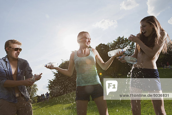 Teenage girls and boy playing in park