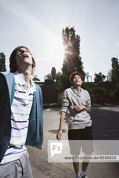 Teenage boys standing in playground  looking up