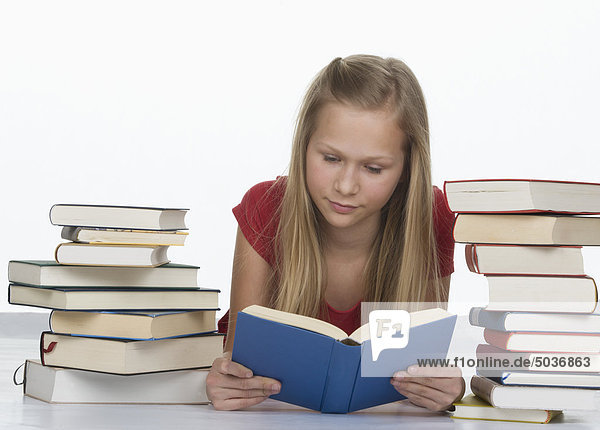 Mädchen-Lesebuch neben Buchstapel vor weißem Hintergrund