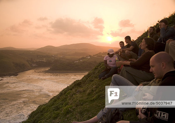 Eine Gruppe von Touristen sitzen Hügel mit Blick auf Kaffee Bay genießen der Sonnenuntergang  Transkei  South Africa