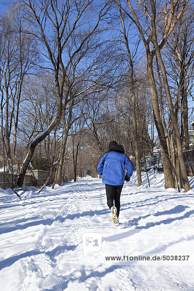 Man running on snow-covered path in winter  Toronto  Ontario  Canada