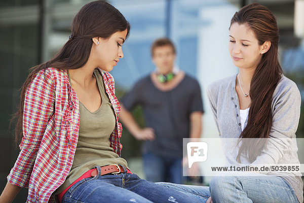 Two female friends sitting in a campus