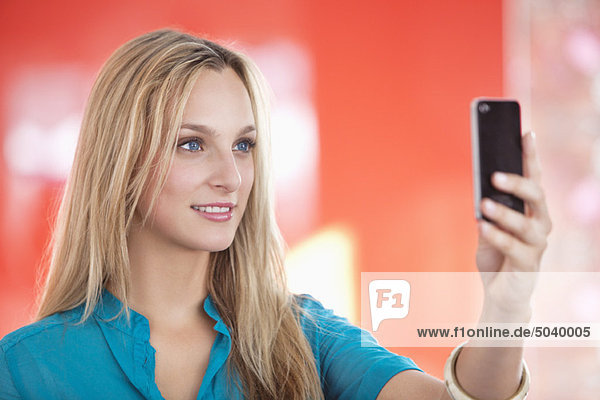 Young woman taking a picture of herself with a mobile phone