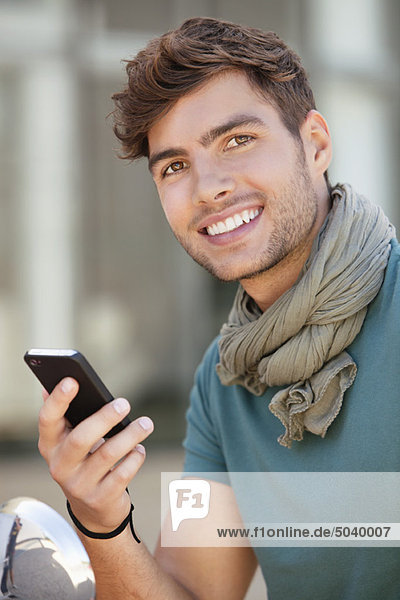 Junger Mann SMS auf dem Handy