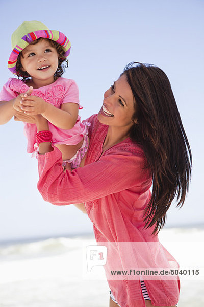 Frau genießt am Strand mit ihrer Tochter