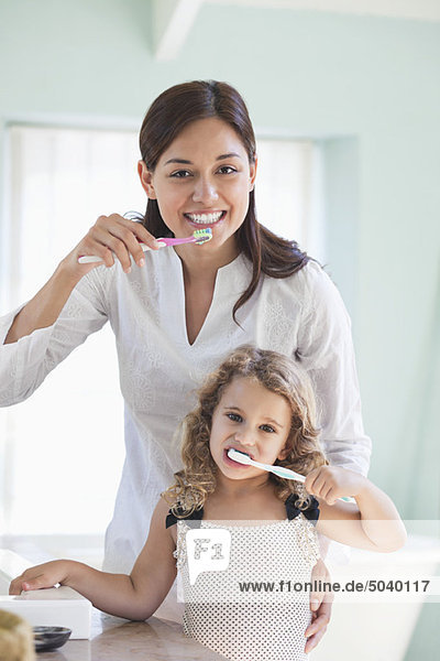 Porträt einer jungen Frau und ihrer Tochter beim Zähneputzen