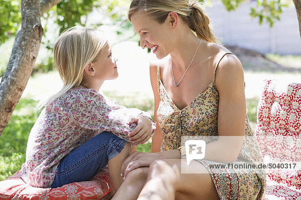 Seitenprofil der Mutter und eines kleinen Mädchens  die sich im Freien sehen.