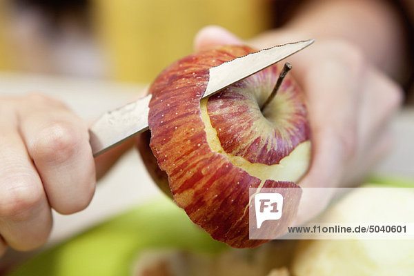 Nahaufnahme der Männerhand beim Schälen eines Apfels