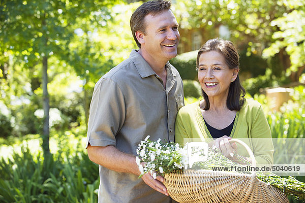 Man with his mother holding basket of flowers outdoors