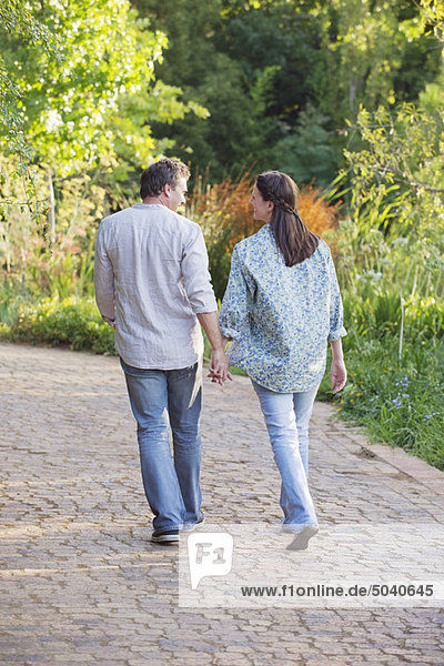 Rear view of a mature couple walking in a garden