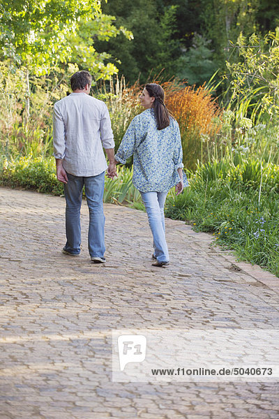 Rear view of a mature couple walking in a garden