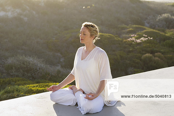 Mittlere erwachsene Frau beim Meditieren