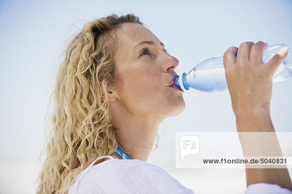 Seitenprofil einer schönen Frau beim Trinken von gereinigtem Wasser