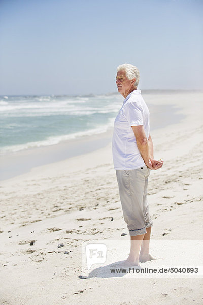 Side profile of a senior man standing on the beach