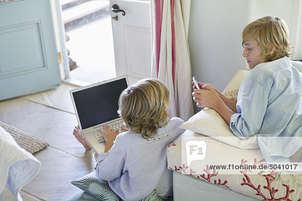 Children using electronic gadgets at home