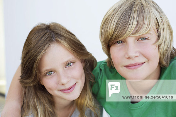 Porträt eines Teenagers  der mit seiner Schwester lächelt
