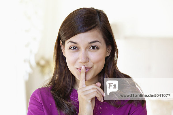 Portrait of a woman showing keep silence gesture
