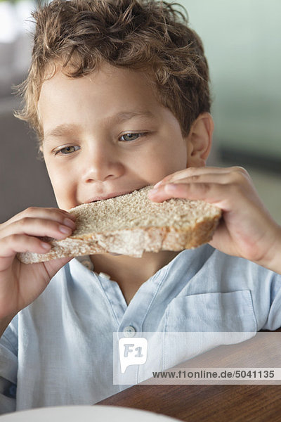 Close-up of a boy eating bread