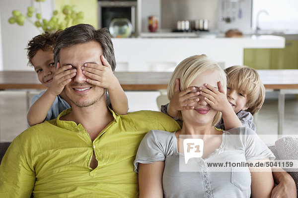 Children covering parents eyes