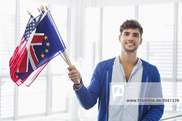Porträt eines Mannes mit Flaggen verschiedener Länder am Flughafen
