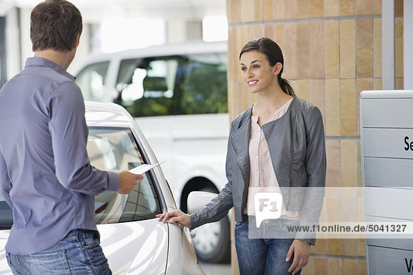 Couple buying a car in showroom