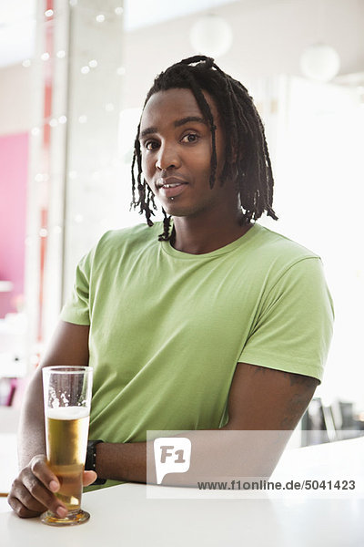 Porträt eines Mannes beim Bier trinken an einer Bar