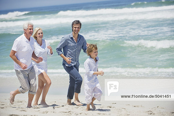 Multi generation family running on the beach