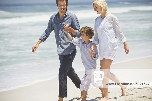 Couple with their son walking on the beach