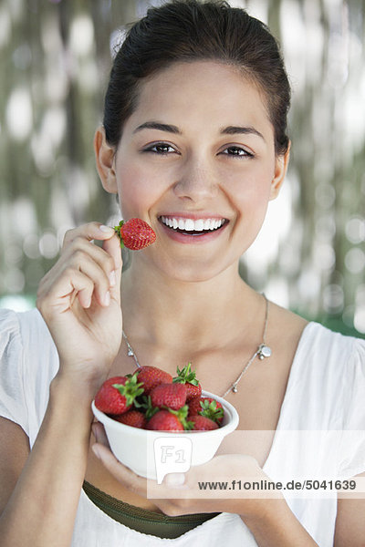 Porträt einer jungen Frau mit einer Schüssel Erdbeeren