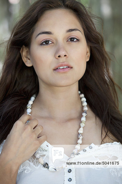Portrait of a beautiful young woman wearing shell's necklace