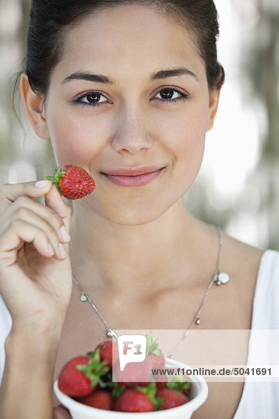 Porträt einer jungen Frau mit einer Schüssel Erdbeeren
