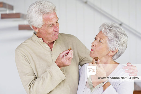 Senior couple eating chocolates
