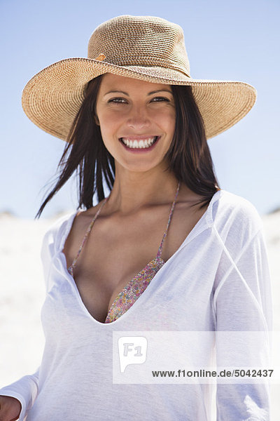 Porträt einer jungen Frau  die am Strand lächelt