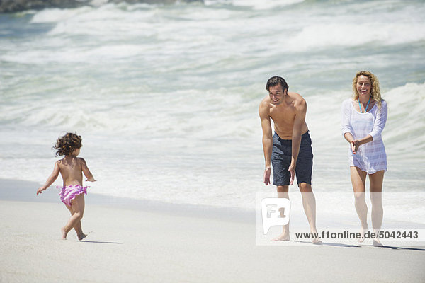 Glückliche Familie beim Spielen am Strand