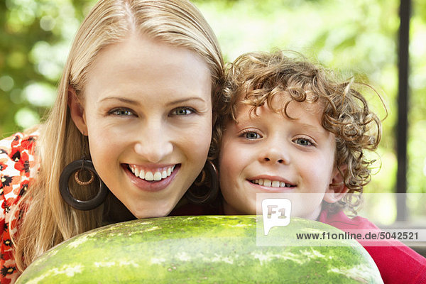 Mother and son leaning on watermelon