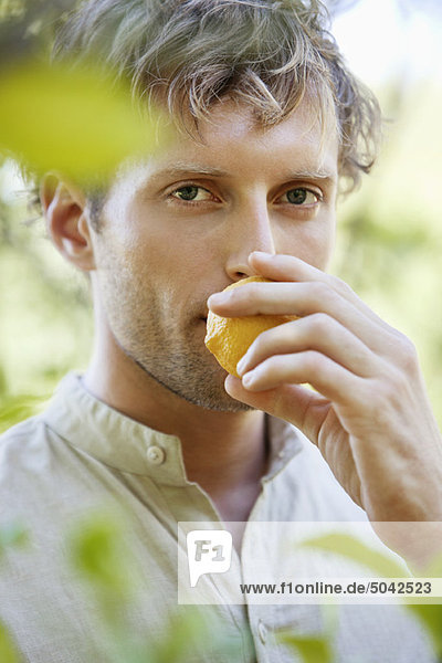 Close-up of a man smelling a lemon