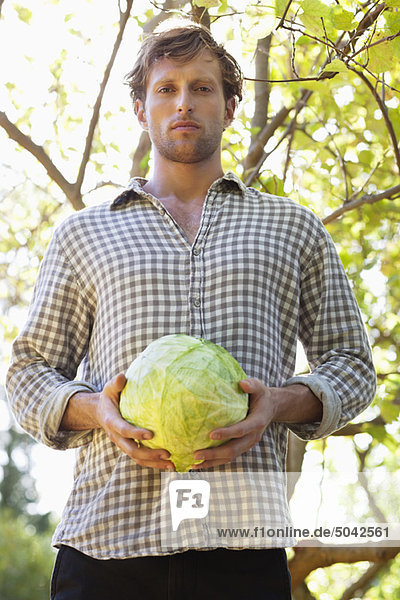 Portrait of a man holding a cabbage
