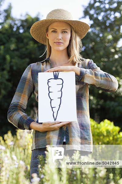 Porträt einer jungen Frau mit Karottenmalerei auf einem Feld