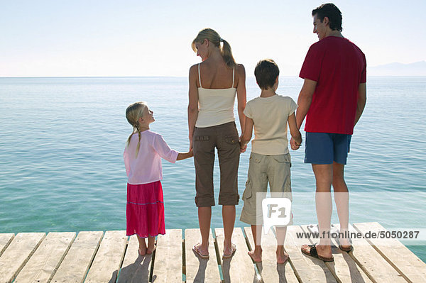 Rear view of family standing on jetty