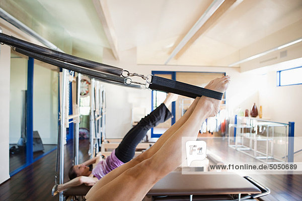 Two women doing pilates in gym