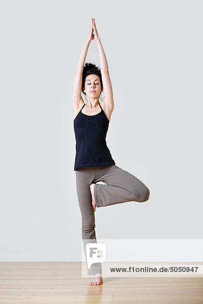 Frau im Baum Position während yoga