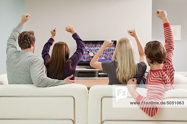 Vier Freunde beim Fußball schauen im Fernsehen